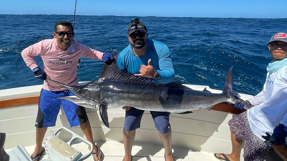 Tres hombres sosteniendo un pez marlin