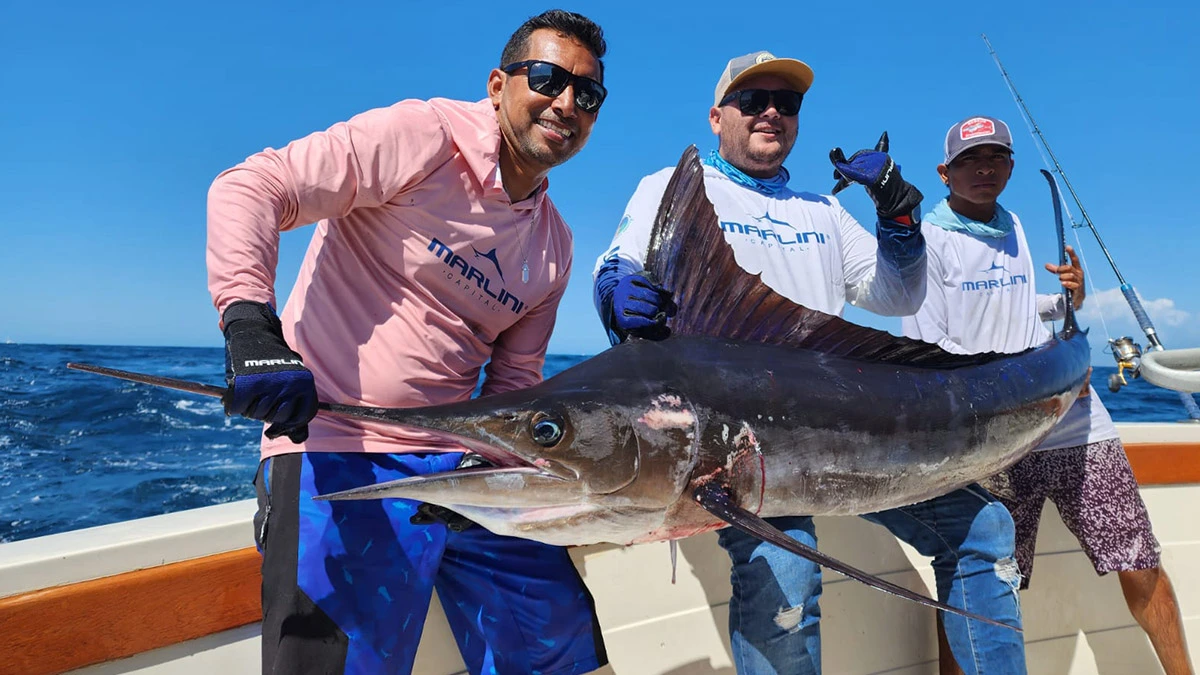 Tres hombres sosteniendo un pez marlin